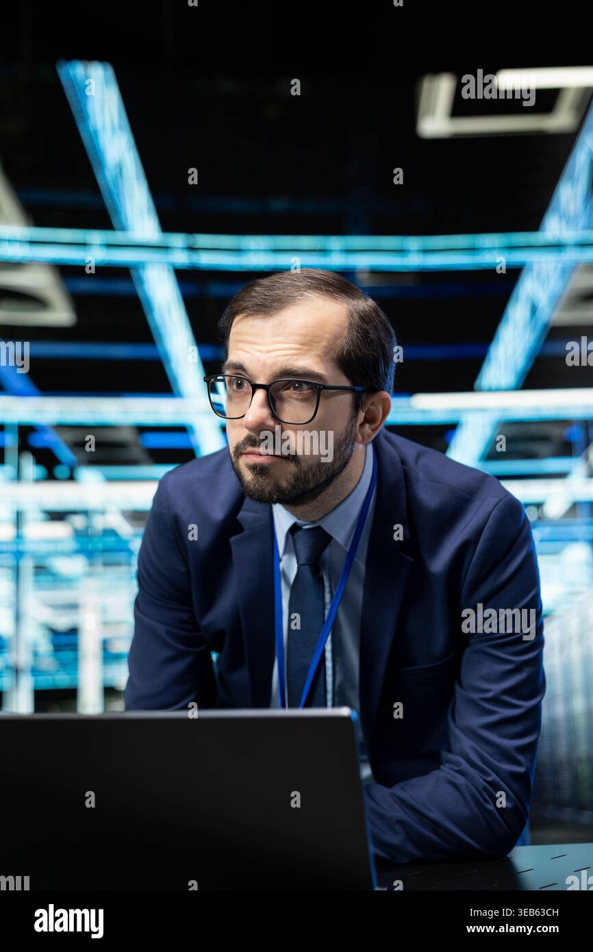 Upgrading equipment, laptop and engineer in data center with database storage. Updating cloud computing rigs, notebook device and software developer in server farm, technology systems concept Stock Photo
