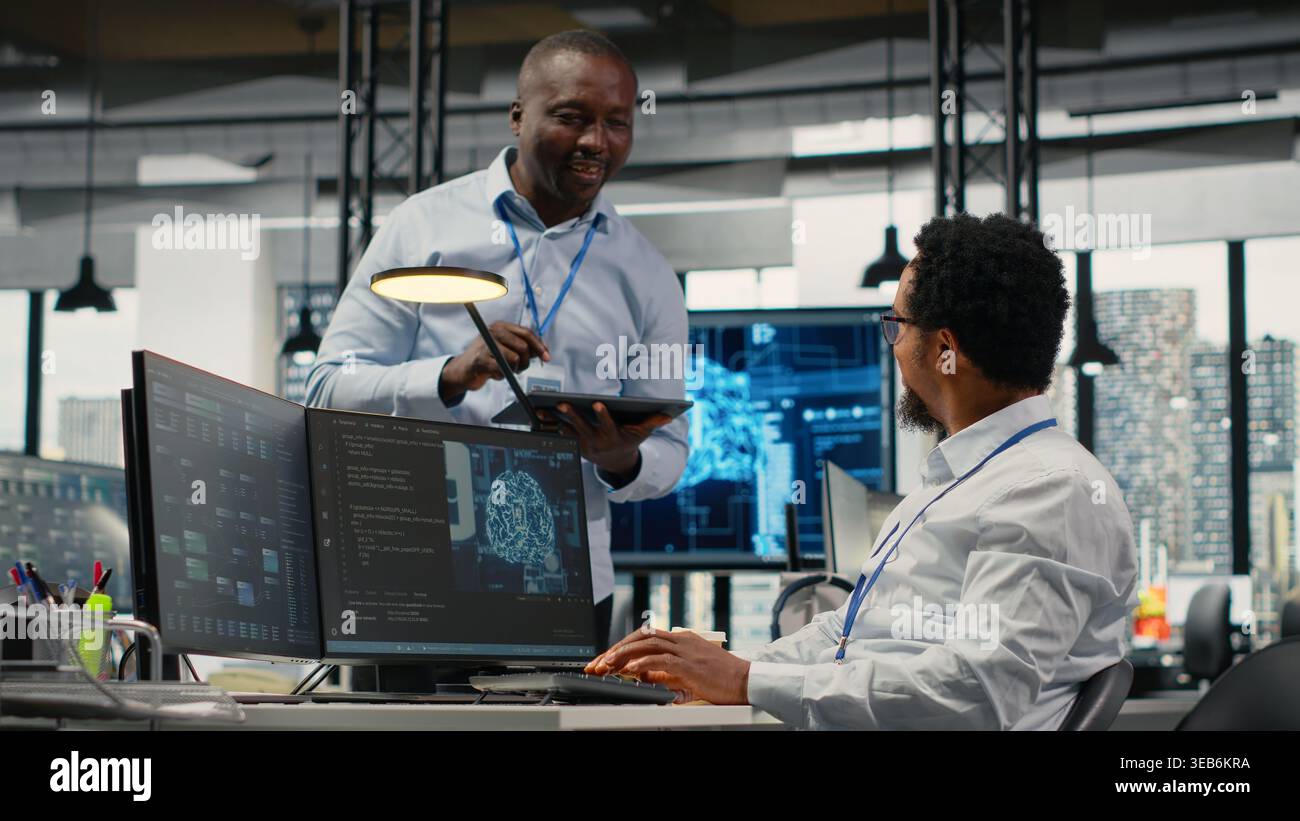 Smiling programmers working in AI startup train predictive models for language processing tasks. Cheerful IT professionals use machine learning technical expertise for complex tasks, camera B Stock Photo