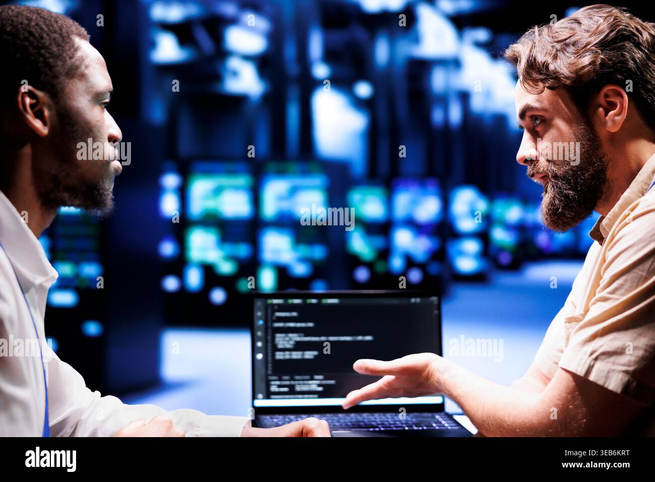 Adept IT developers colleagues writing script code in server hub on laptop terminal. Experienced programmer team doing maintenance work in cloud computing computer business updating racks software Stock Photo