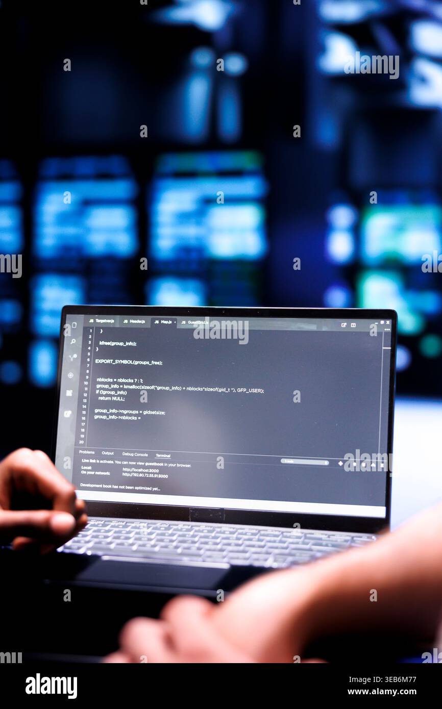 Admin team maintaining and updating server rigs, writing lines of code on laptop terminal, close up. Coders using JavaScript, Java, and database programming to ensure seamless data center computing Stock Photo