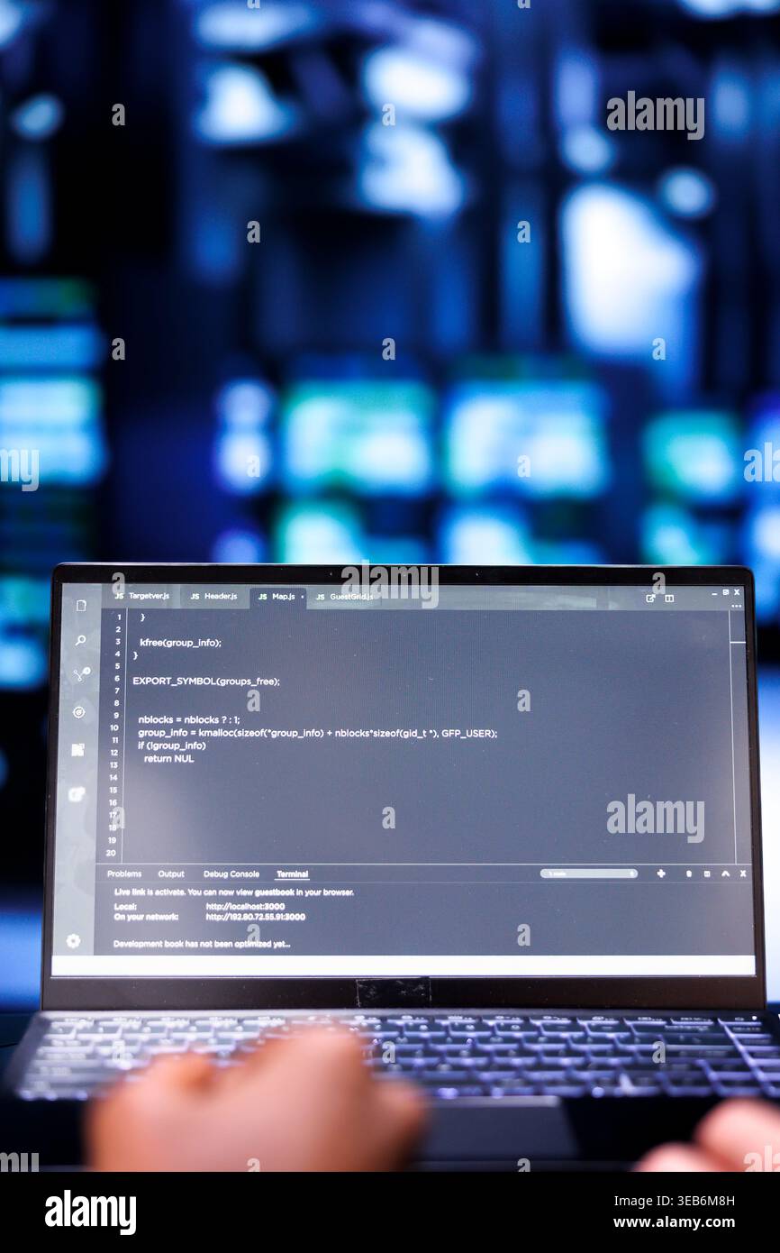 Close up shot of developers updating server rigs, writing complex binary code scripts on laptop. Programmers using JavaScript, Java, and database programming to fortify cybersecurity in data center Stock Photo