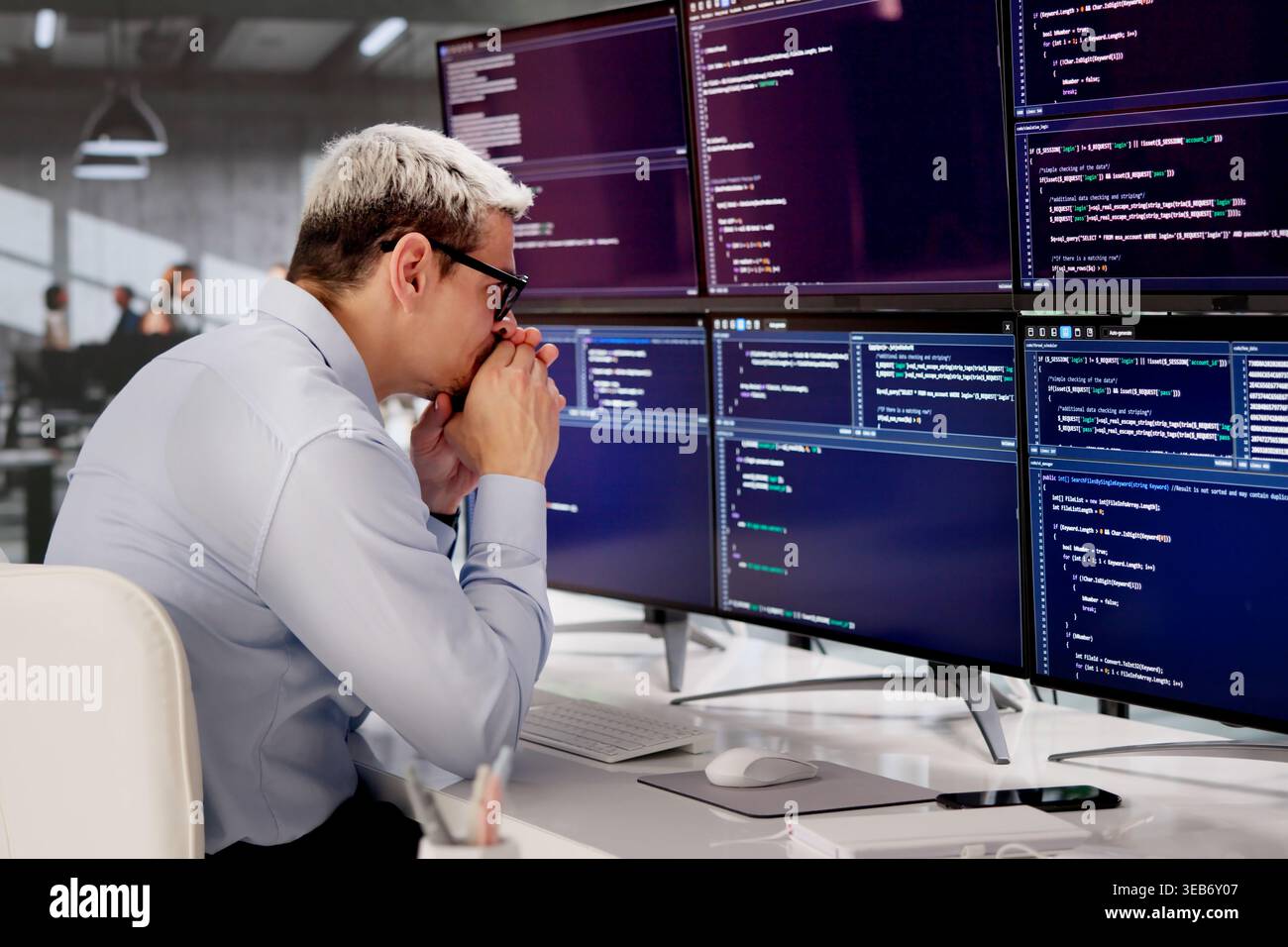 Frustrated Male Developer Struggling With Complex Web Code At Office Desk Stock Photo