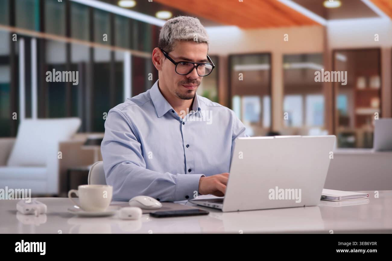 Focused Entrepreneur Using Laptop In Home Office Setting Stock Photo