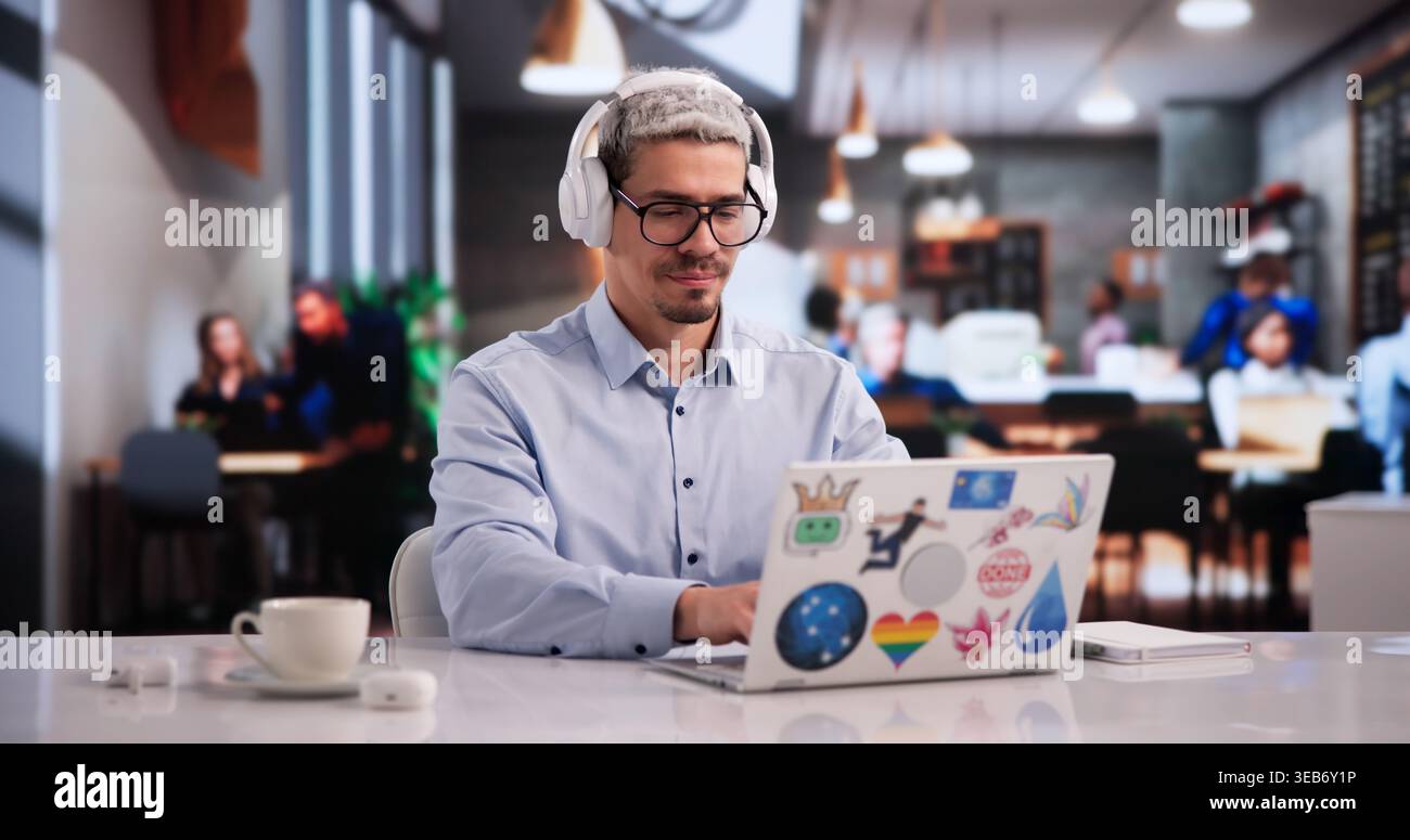 Determined Graphic Design Student Focused On Laptop In Lively Coffee Shop Stock Photo