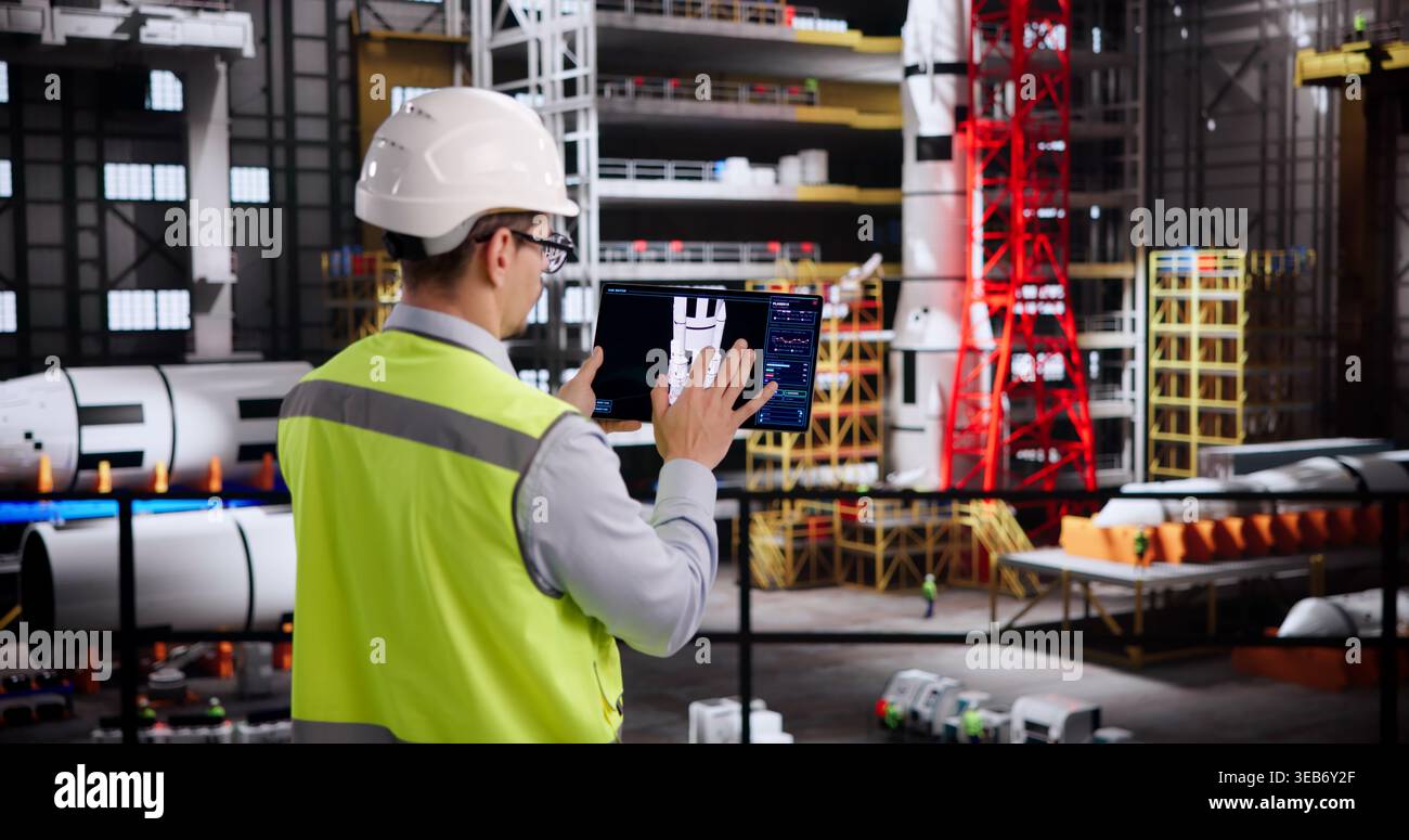 Hispanic Engineer Programs Cutting-Edge Automation Technology With Tablet Device Stock Photo