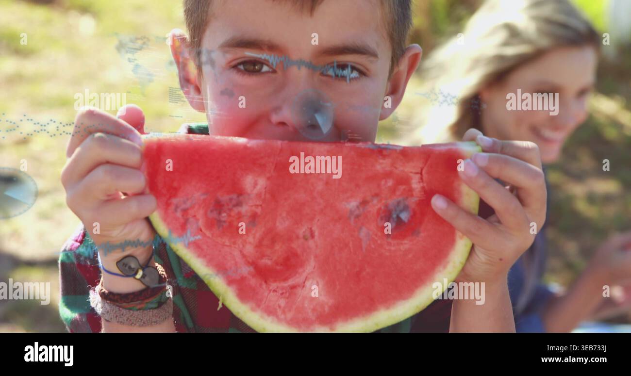 Biting child wearing plaid flannel shirt holding watermelon slice at park, with bracelets and watch Stock Photo