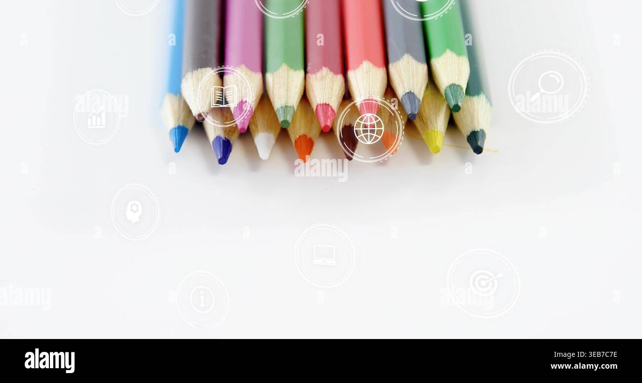 Displaying eleven sharpened colored pencils with tips down on white sheet, showing faint icons Stock Photo