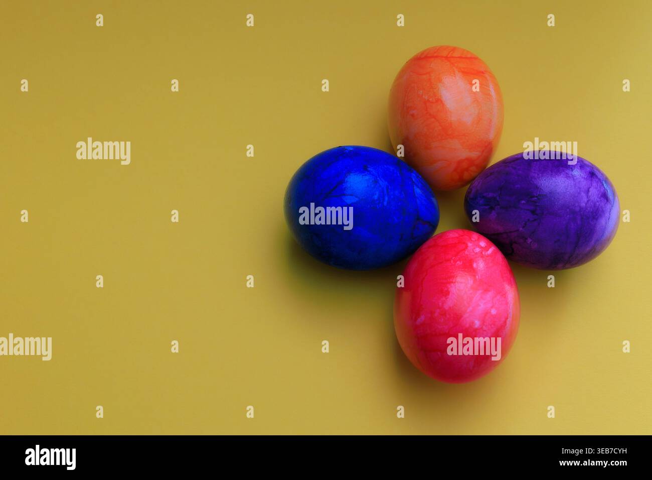 Different colored Easter eggs on a colored background Stock Photo