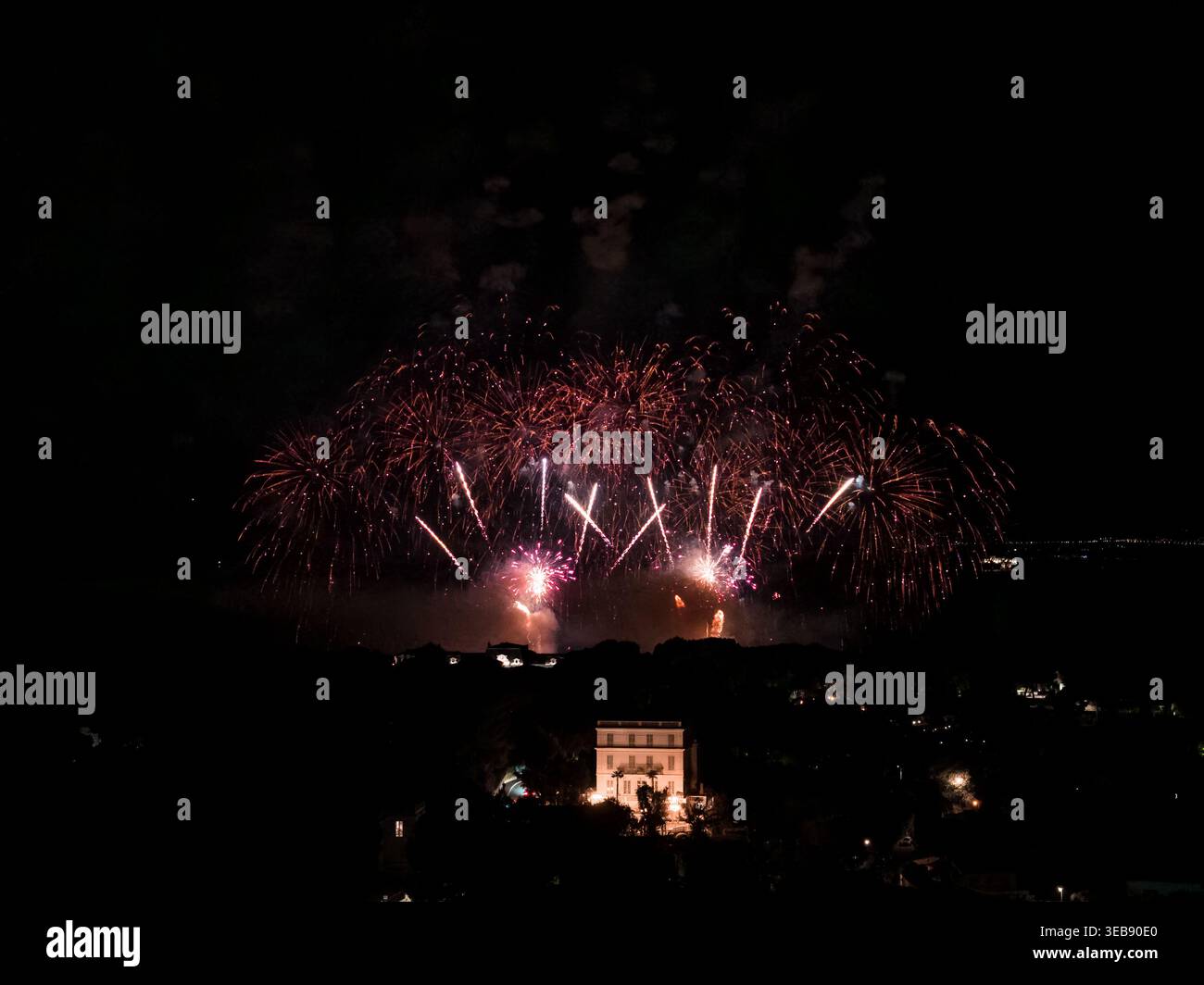 Fireworks in red and gold over Antibes bay with historic landmark Stock Photo