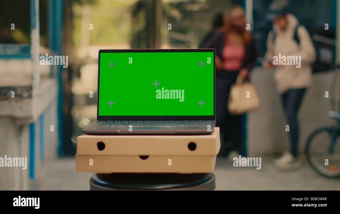 Laptop advertising greenscreen template outside, food delivery service at front door. Running isolated chroma key display with blank mockup and copyspace background on computer screen. Stock Photo