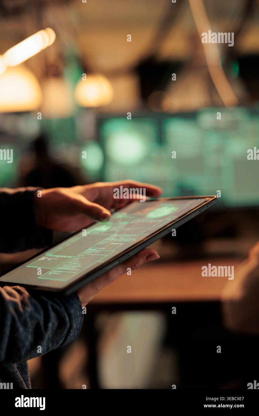 Woman analyzing computer network to hack system on tablet, using code and encrytion to break into security server. Female spy trying to hack database and steal sensitive information. Stock Photo