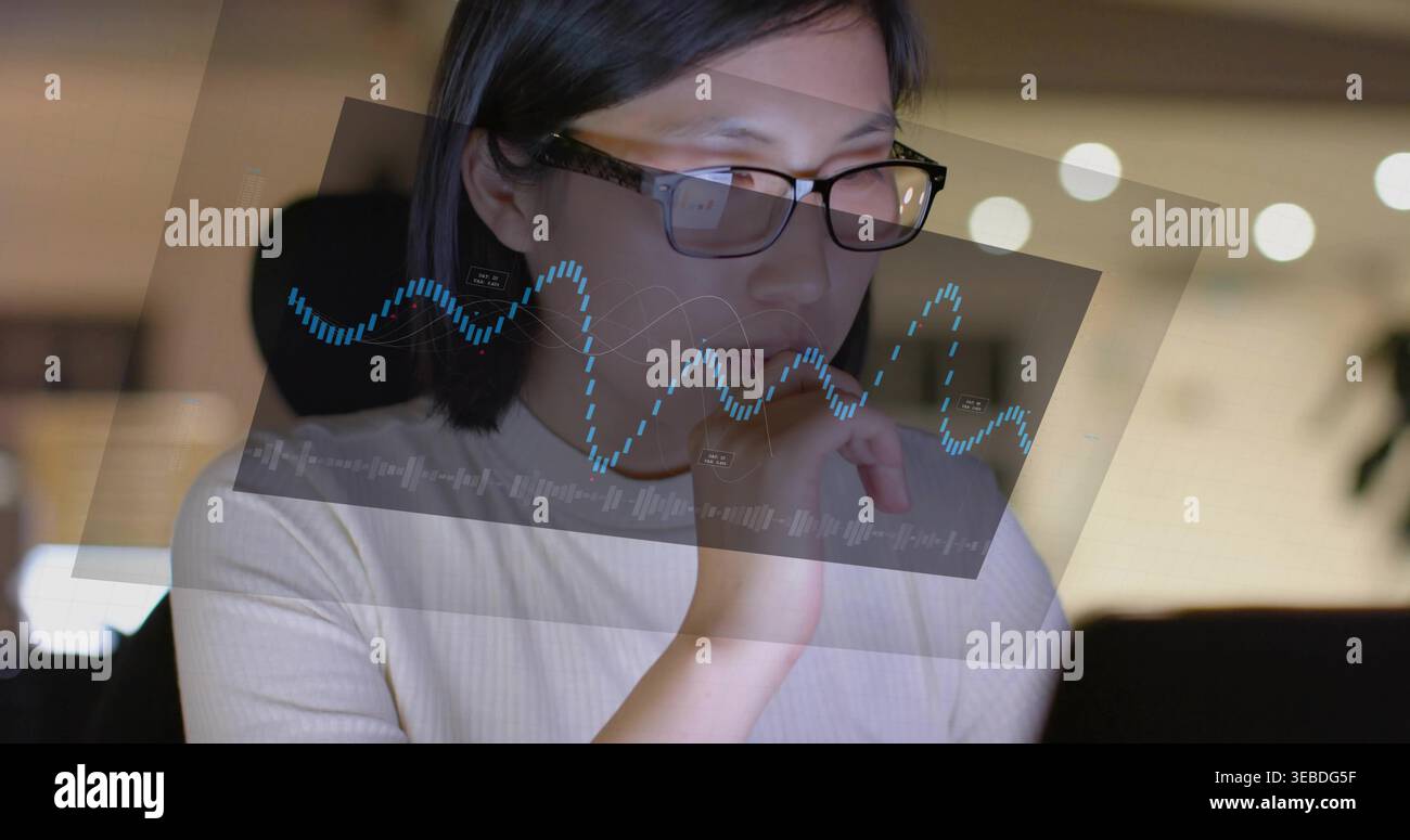 Analyzing woman scanning data at laptop, wearing glasses, ribbed top with blue waveform overlay Stock Photo