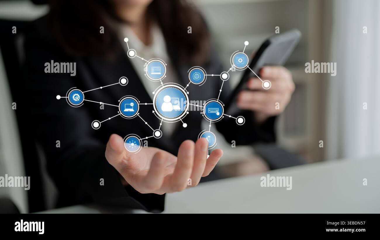 A business professional interacts with a smartphone while showcasing a digital network interface. This visual symbolizes communication, innovation Stock Photo