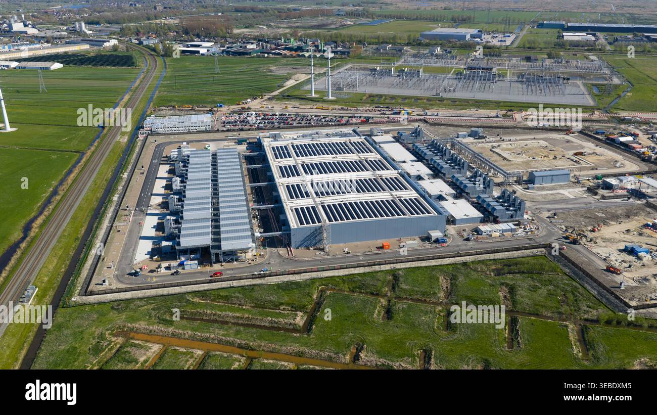 Aerial view of Datacenter Westpoort featuring solar panels on rooftops and surrounding green fields in Groningen, Groningen, Netherlands. Stock Photo