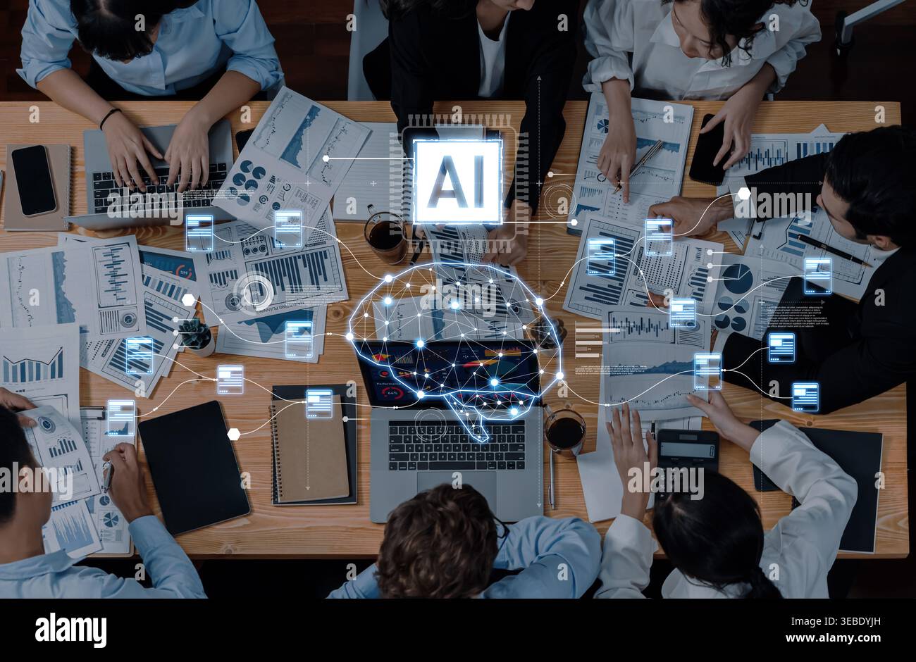 A dynamic business meeting featuring diverse professionals analyzing data, utilizing technology, and collaborating over charts, enhancing decision Stock Photo