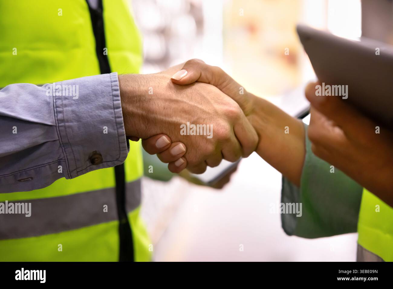 Closeup of two warehouse workers shaking hands Stock Photo