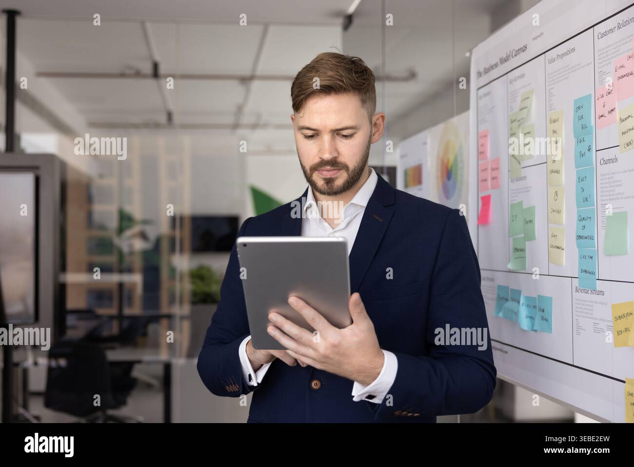 Businessman reviewing digital presentation or analyzing project plan on tablet Stock Photo