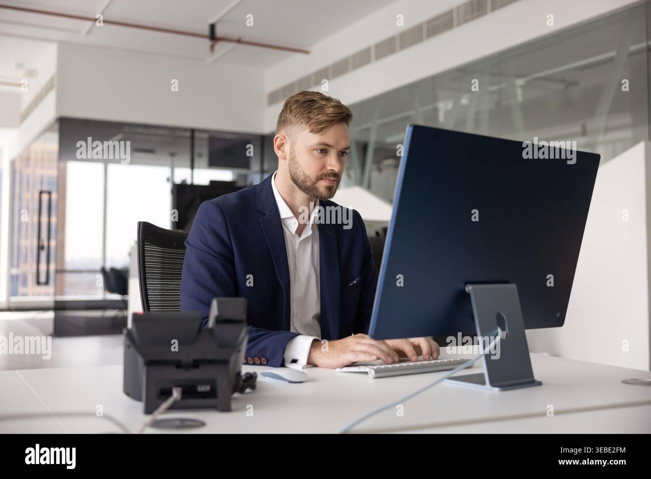 Young businessman working on desktop computer in office Stock Photo