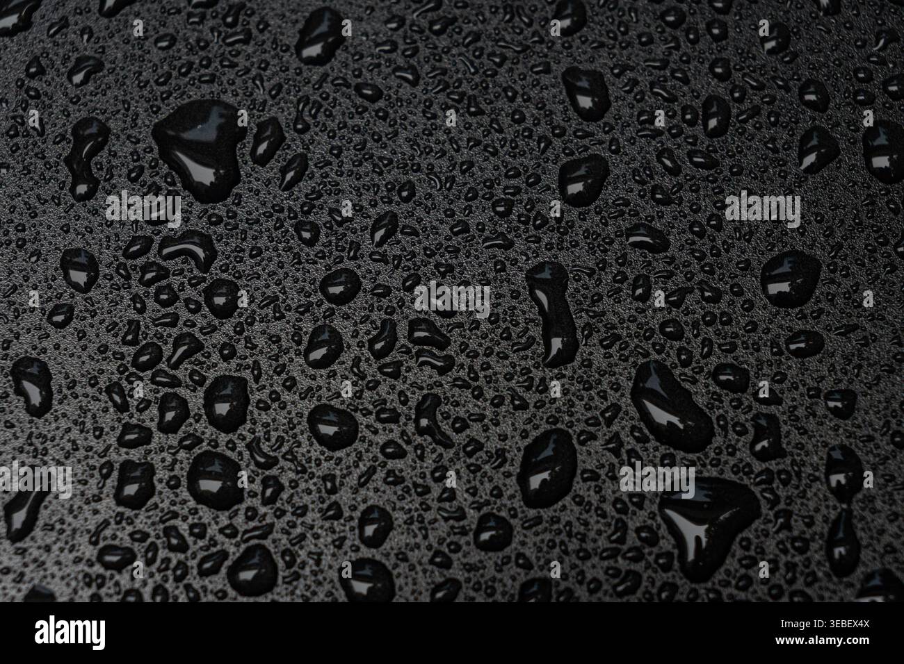 Water Droplets on Black Waterproof Surface Stock Photo
