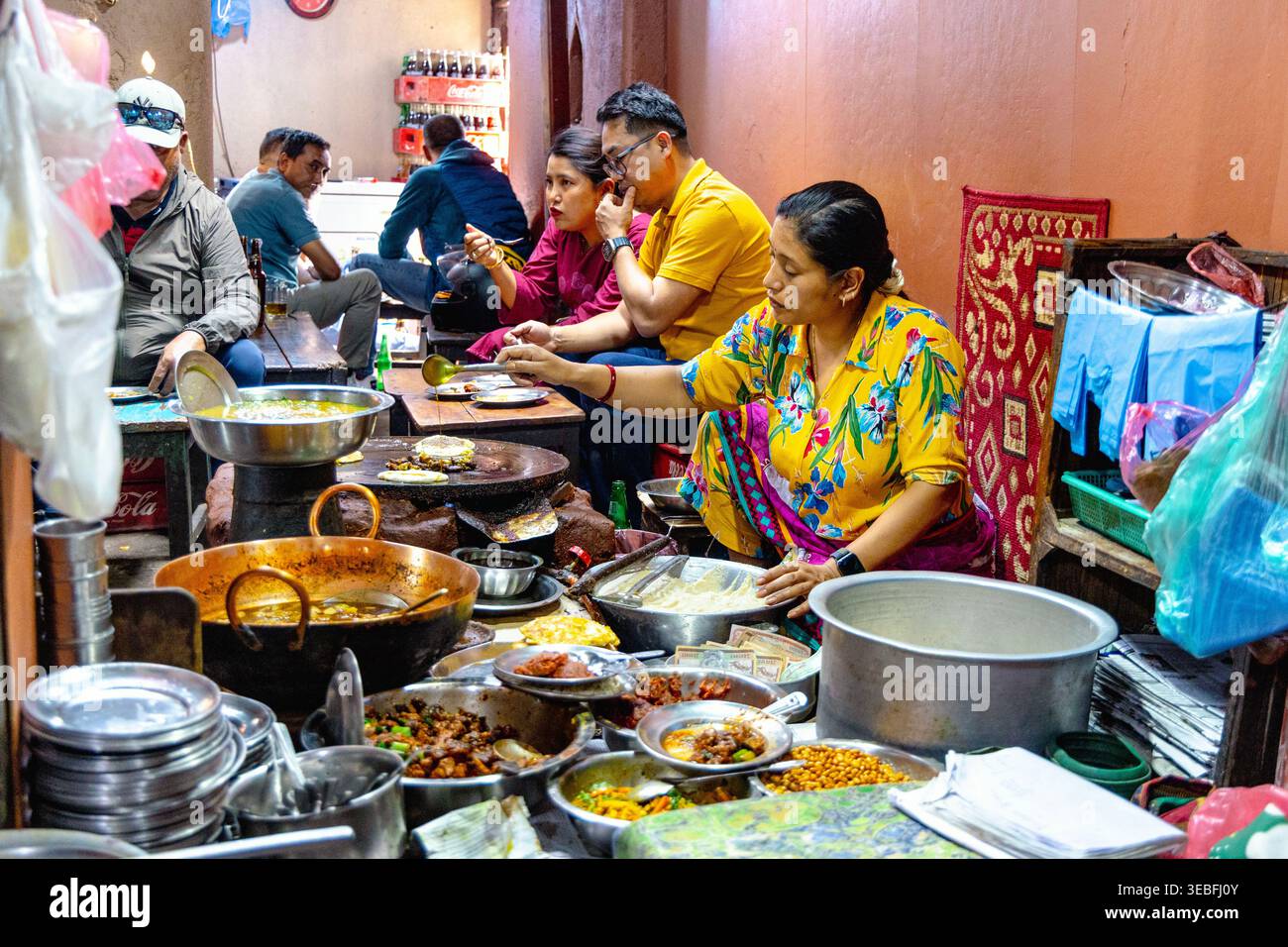 Woman cooking Newari dishes including bara (black lentil pancakes) at Honacha traditional Newari restaurant, Patan (Lalitpur), Nepal Stock Photo