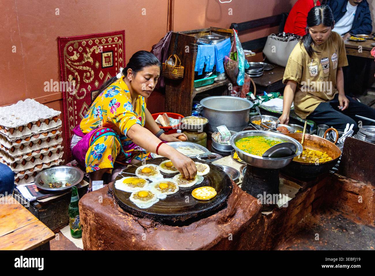 Woman cooking Newari dishes including bara (black lentil pancakes) at Honacha traditional Newari restaurant, Patan (Lalitpur), Nepal Stock Photo