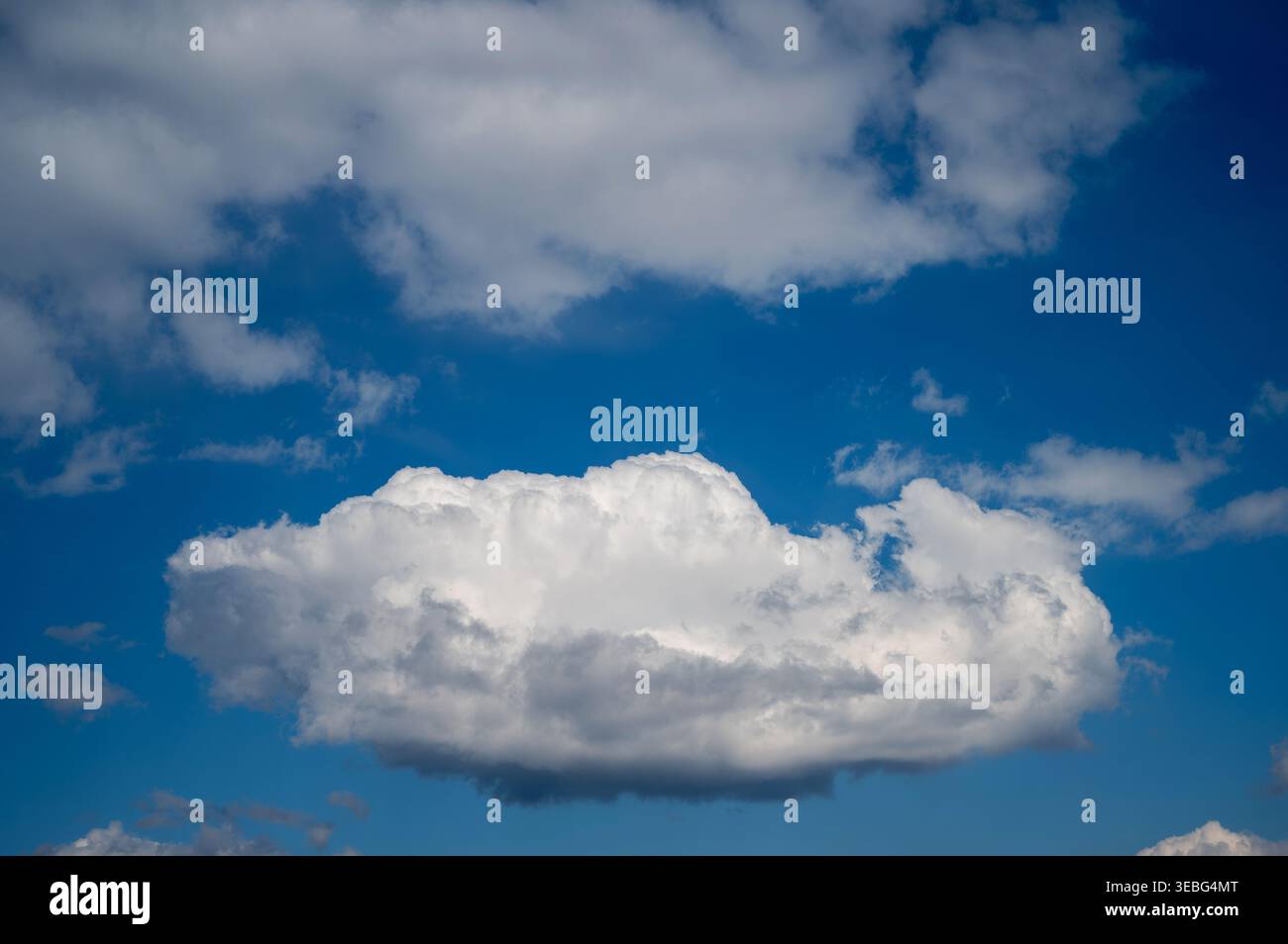 Bright white cloud floating in deep blue sky Stock Photo