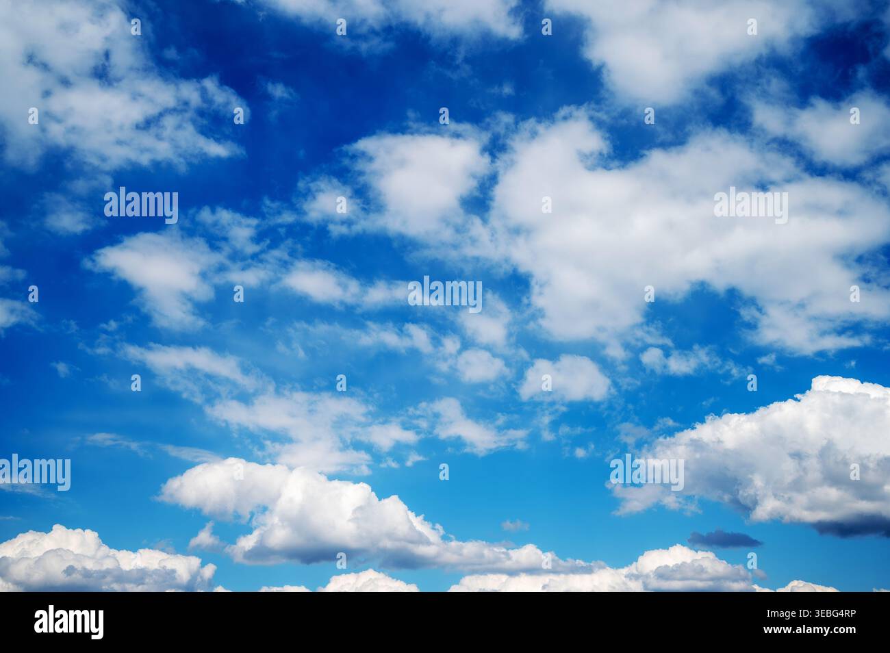 Blue sky filled with scattered white clouds background Stock Photo