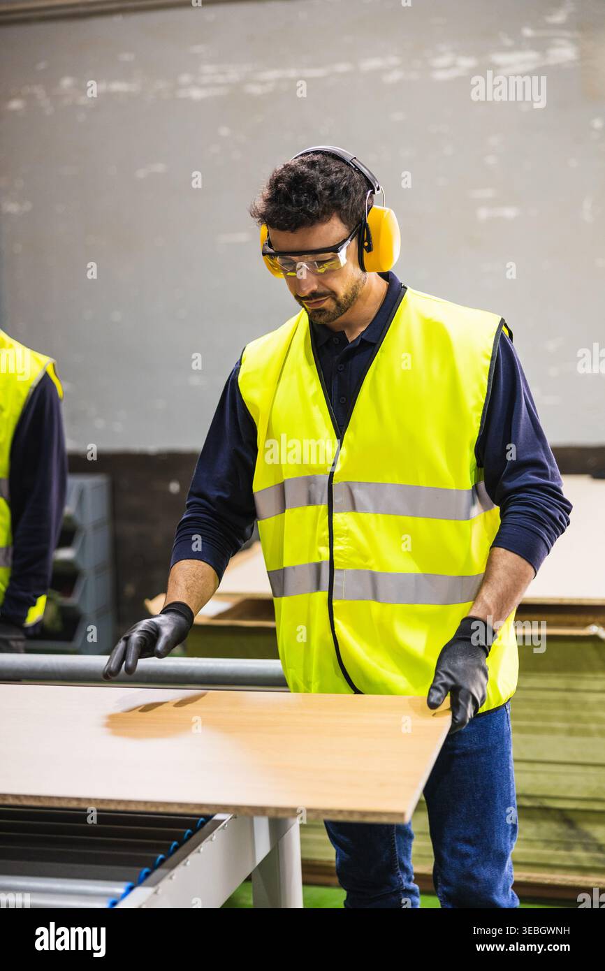 Factory worker operating machinery in a lumberyard Stock Photo