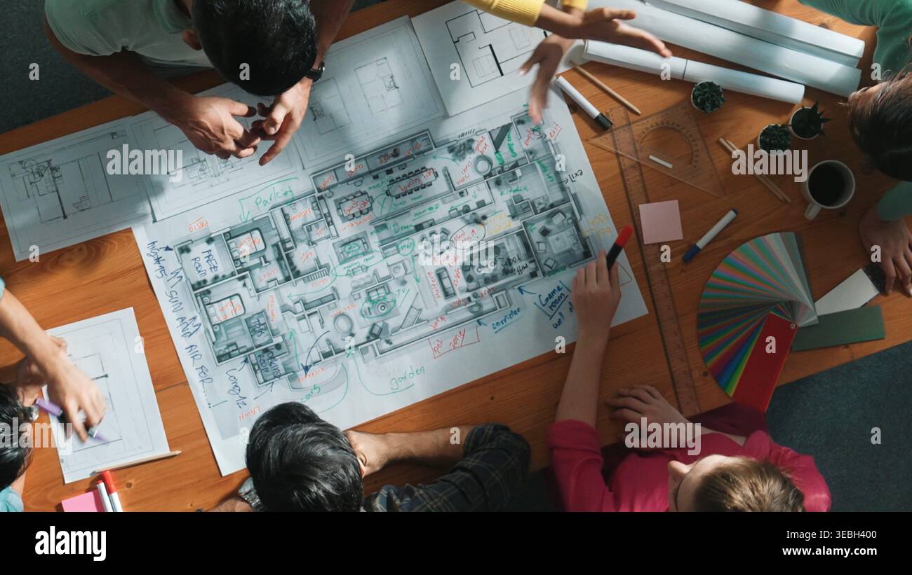 Top down view of civil engineer team writing at blueprint at meeting ...