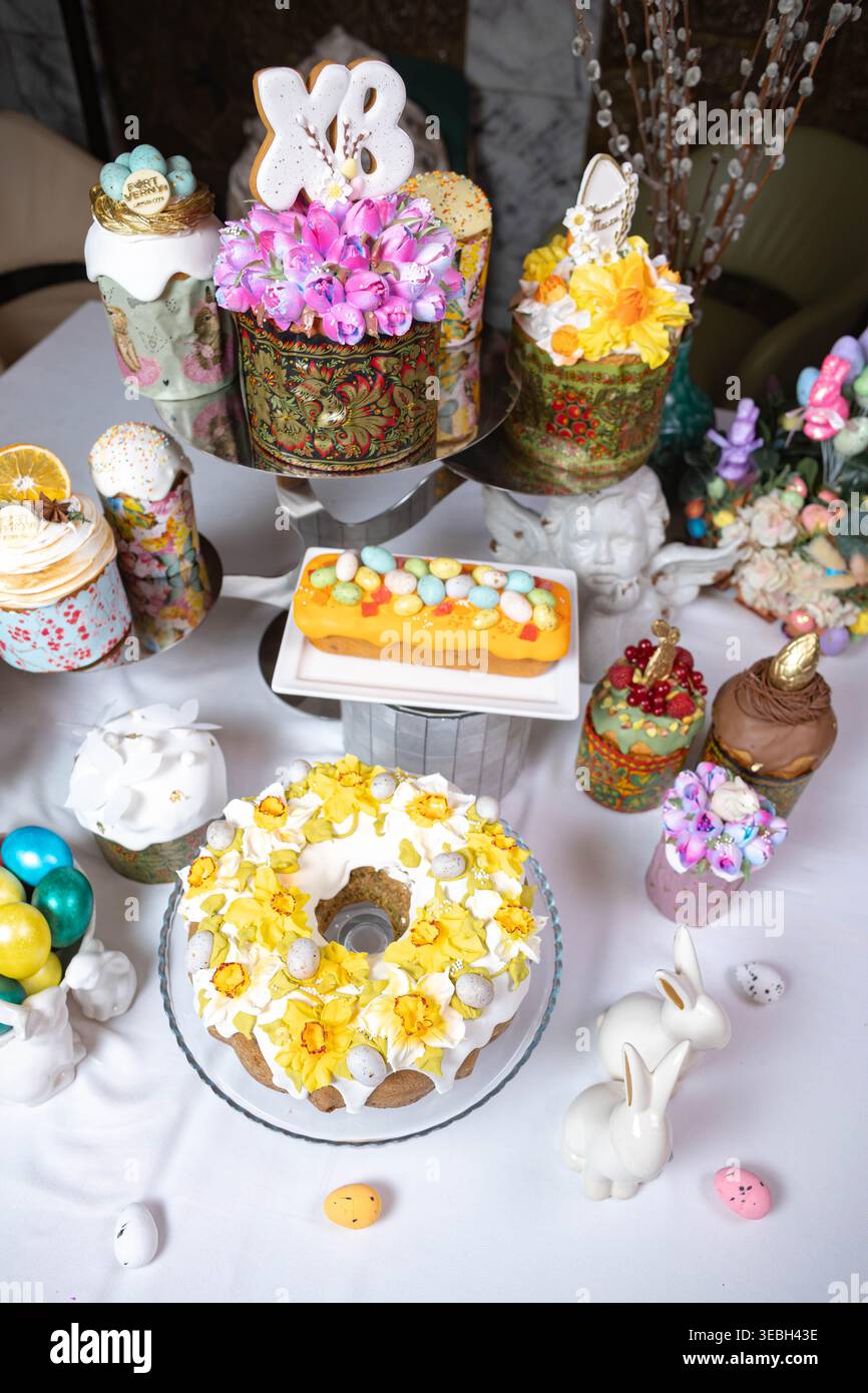 Vertical view of Easter table with cakes, eggs, and decorative bunnies. Stock Photo