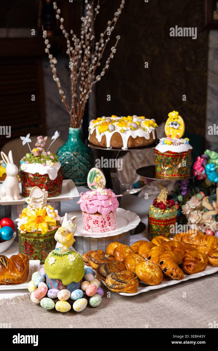 Vertical view of Easter table with cakes, eggs, and decorative bunnies. Stock Photo