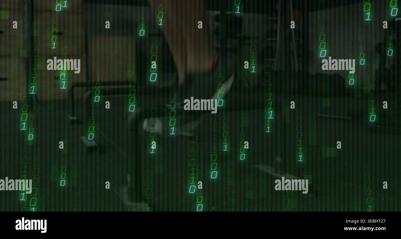 Typing tech wearing dark jacket in dim green office with desk monitors keyboard and binary code Stock Photo