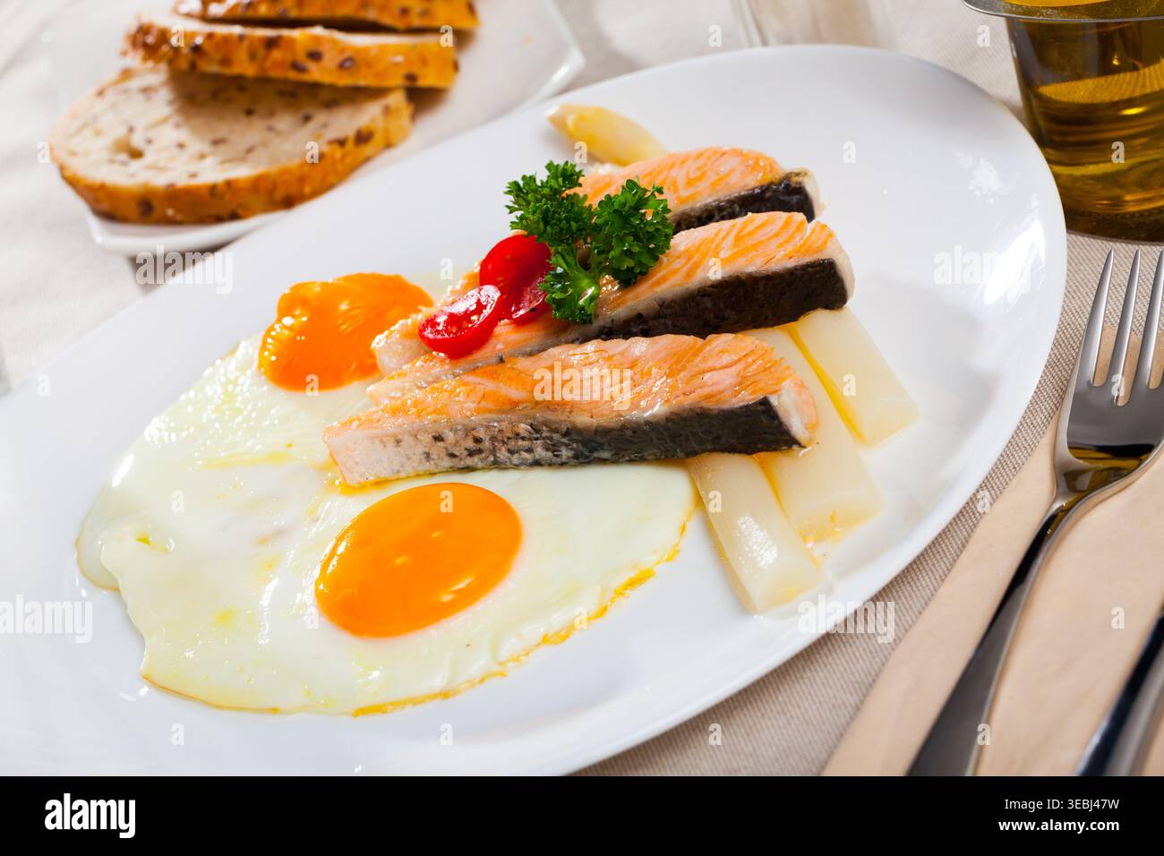 Fried salmon with scrambled eggs and asparagus Stock Photo