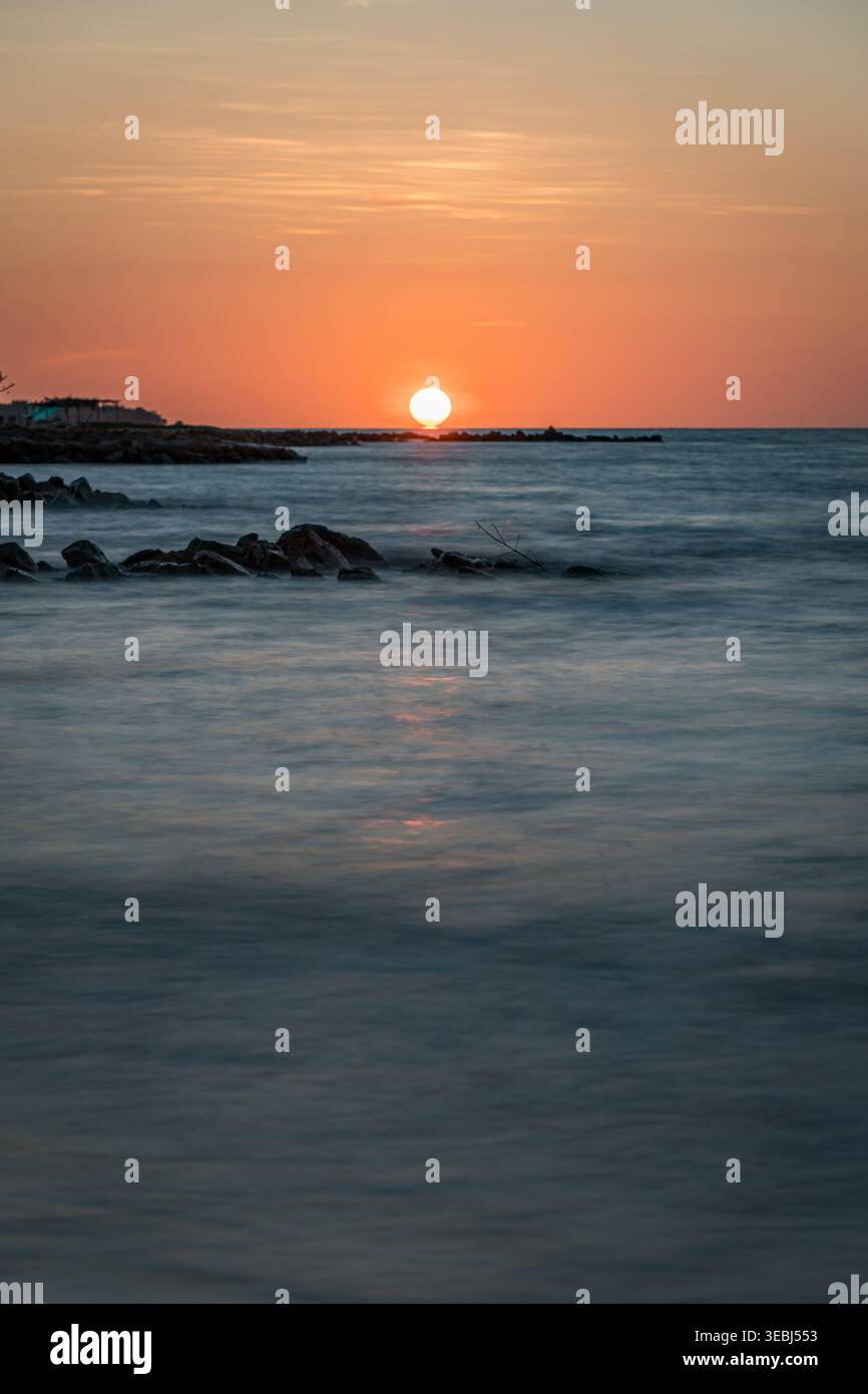 Vibrant sunset light reflecting on tranquil ocean water Stock Photo