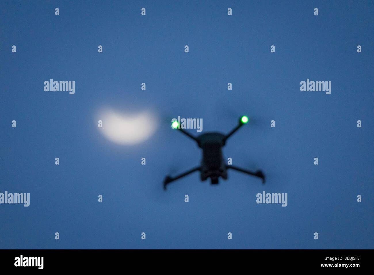 Drone flying during partial solar eclipse at sunset Stock Photo
