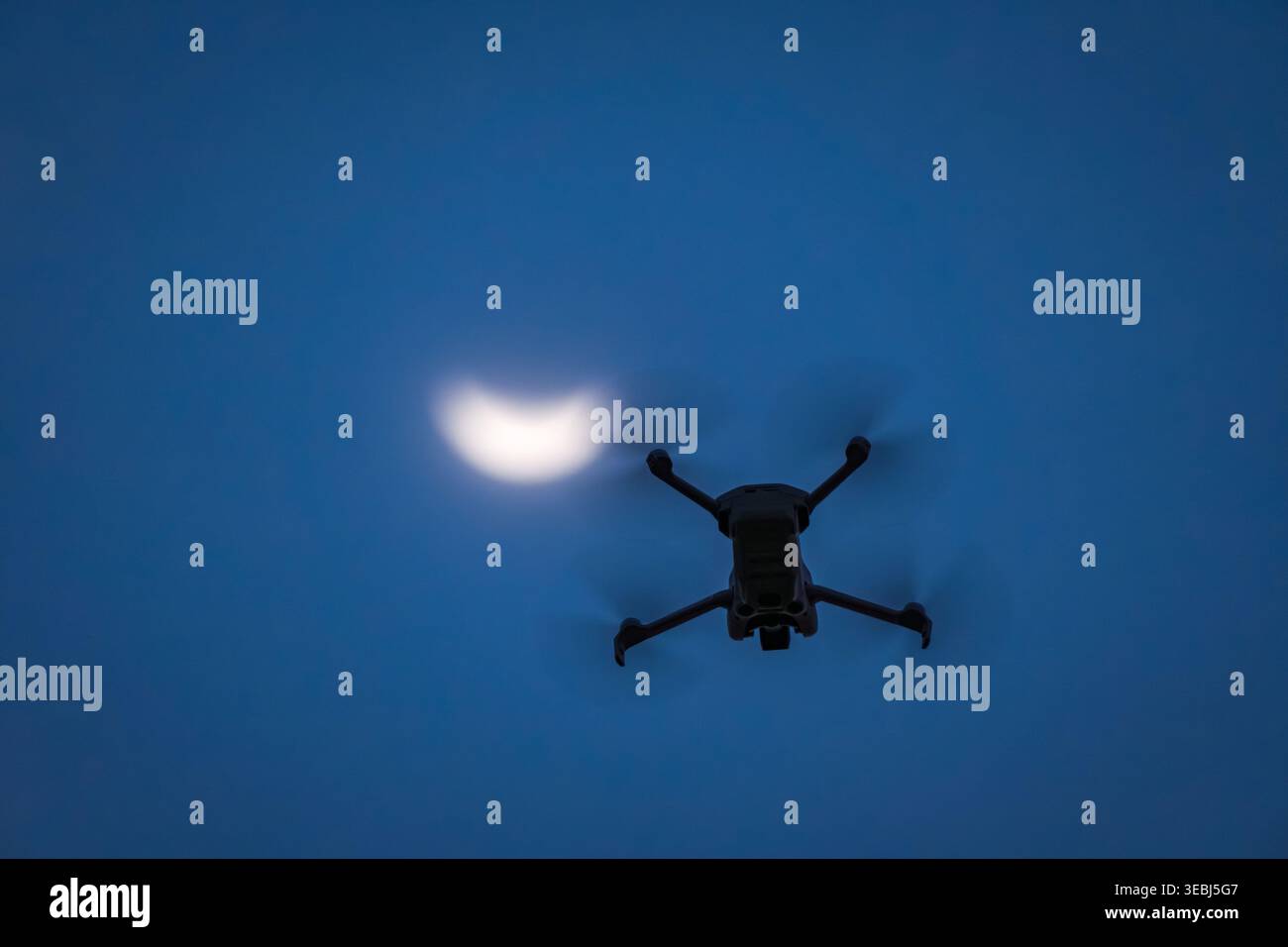 Drone flying during partial solar eclipse at sunset Stock Photo