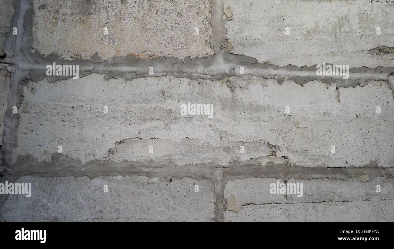 Gray concrete block wall texture featuring visible mortar and lines, creating a repeatable pattern ideal for various design applications Stock Photo