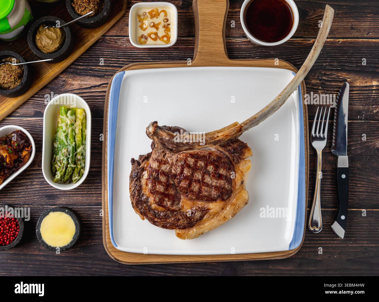 Tomahawk beef steak with spices served on rustic table Stock Photo