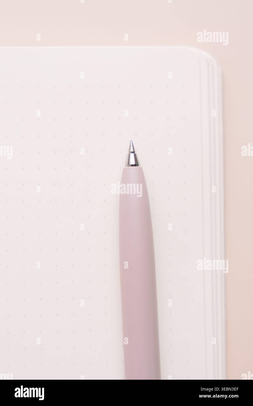 Pink pen and blank notebook page on beige background Stock Photo