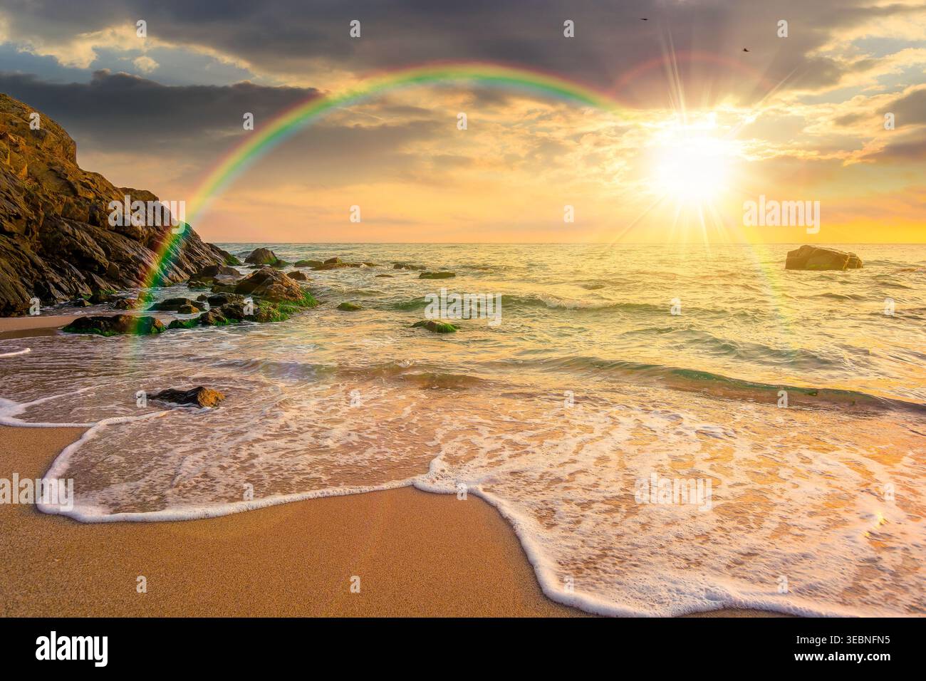 sunset over sandy sea beach. scene on hot summer vacation season. beautiful view of waves washing the sand. generic image of seascape and sky with rai Stock Photo
