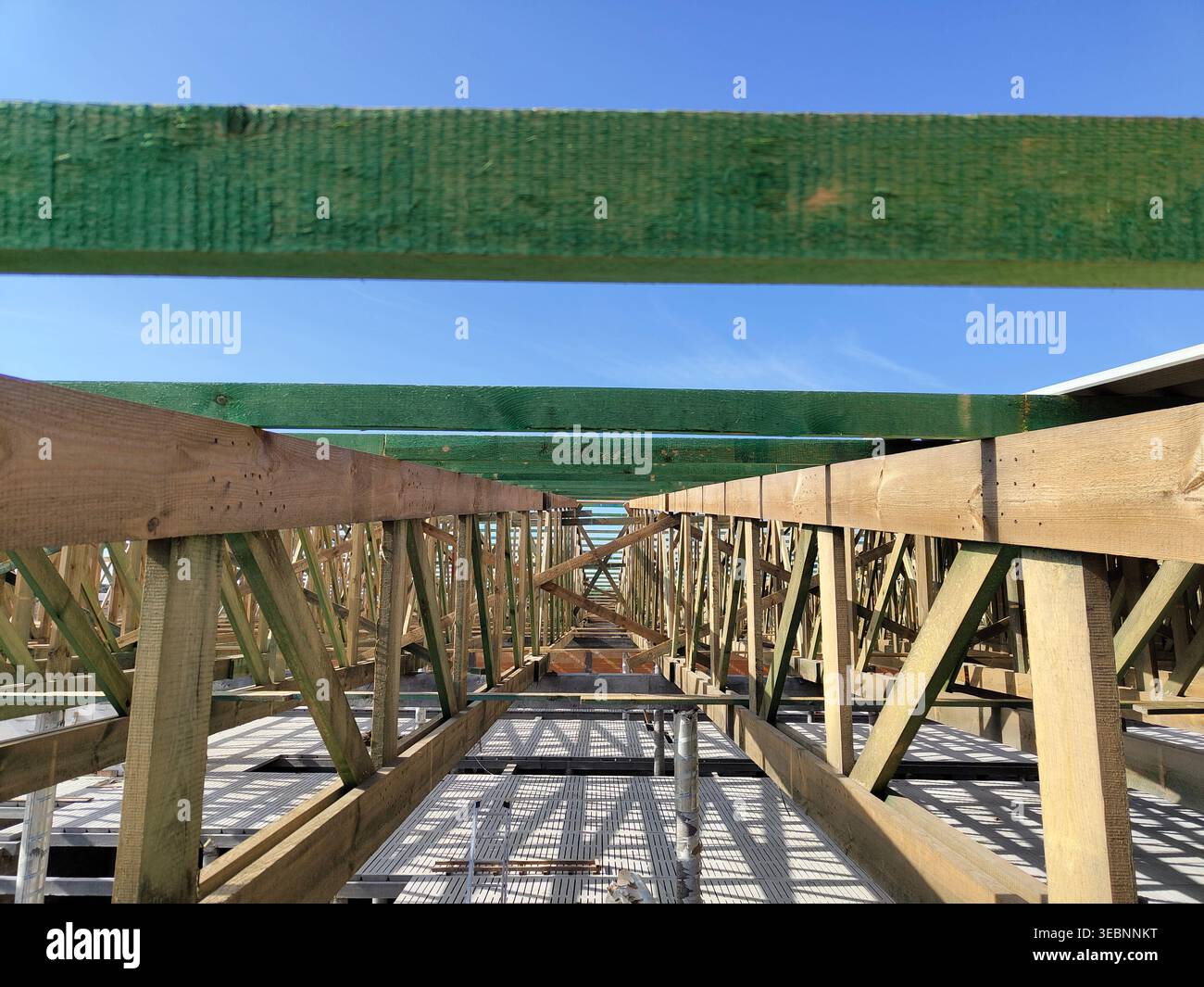Parallel Construction Building Wooden roof truss system with beams arranged in parallel rows above ...