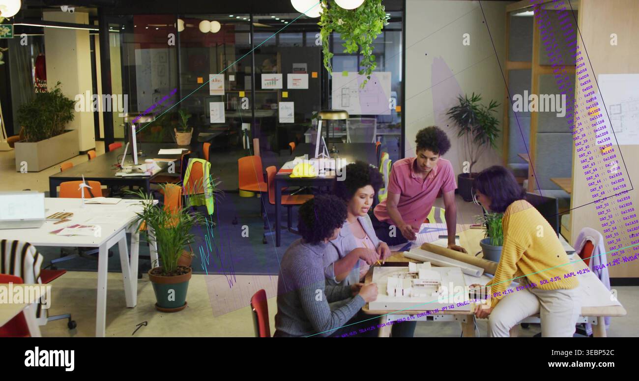 Pointing woman in light blazer leading team, leaning members inspecting scale model, plans, studio Stock Photo