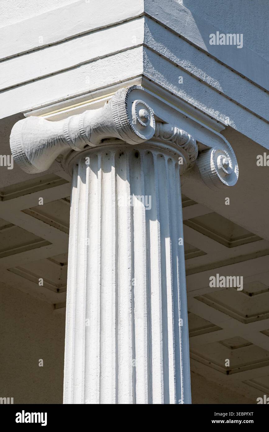 White fluted column with Ionic capital supporting a building corner ...
