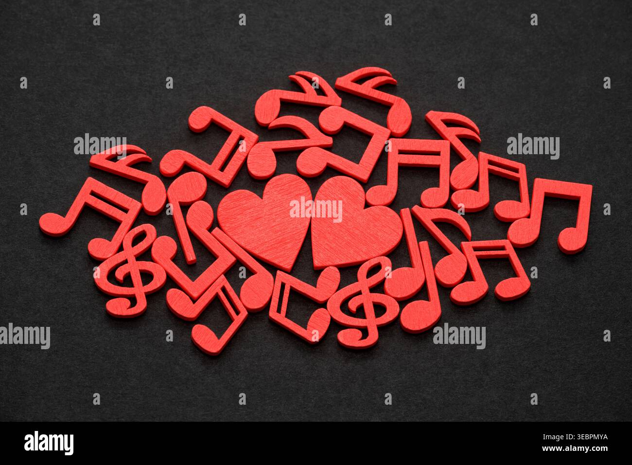 Two red hearts with red musical notes on black background Stock Photo