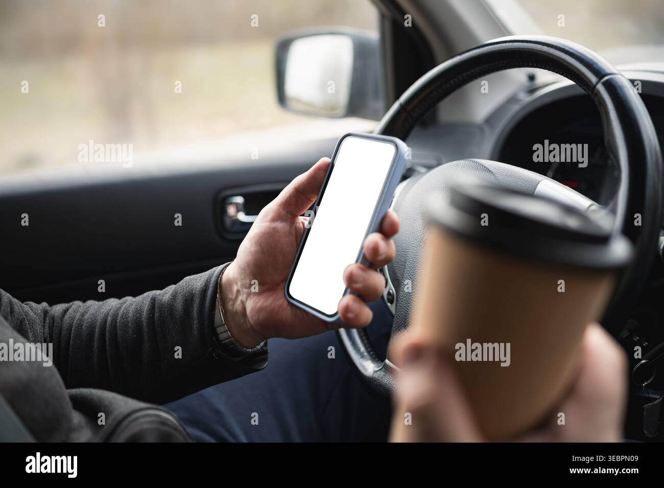 Driver Holding Smartphone And Coffee Cup While Driving Stock Photo