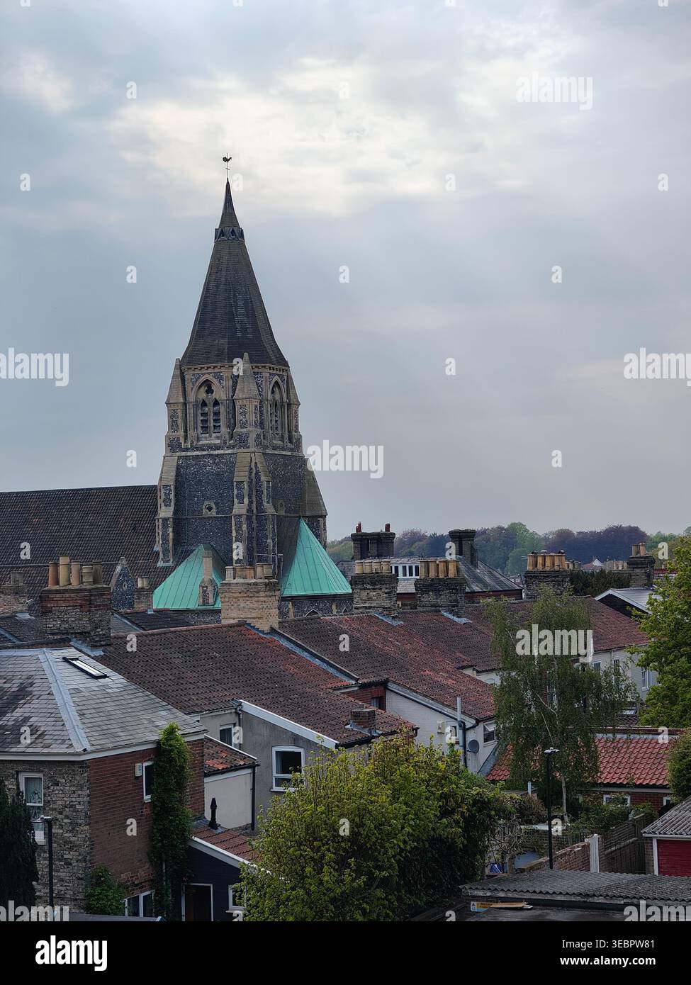 Norwich Cityscape with Church Spire and Rooftops Under Cloudy Sky - Smartphone Captured Stock Image