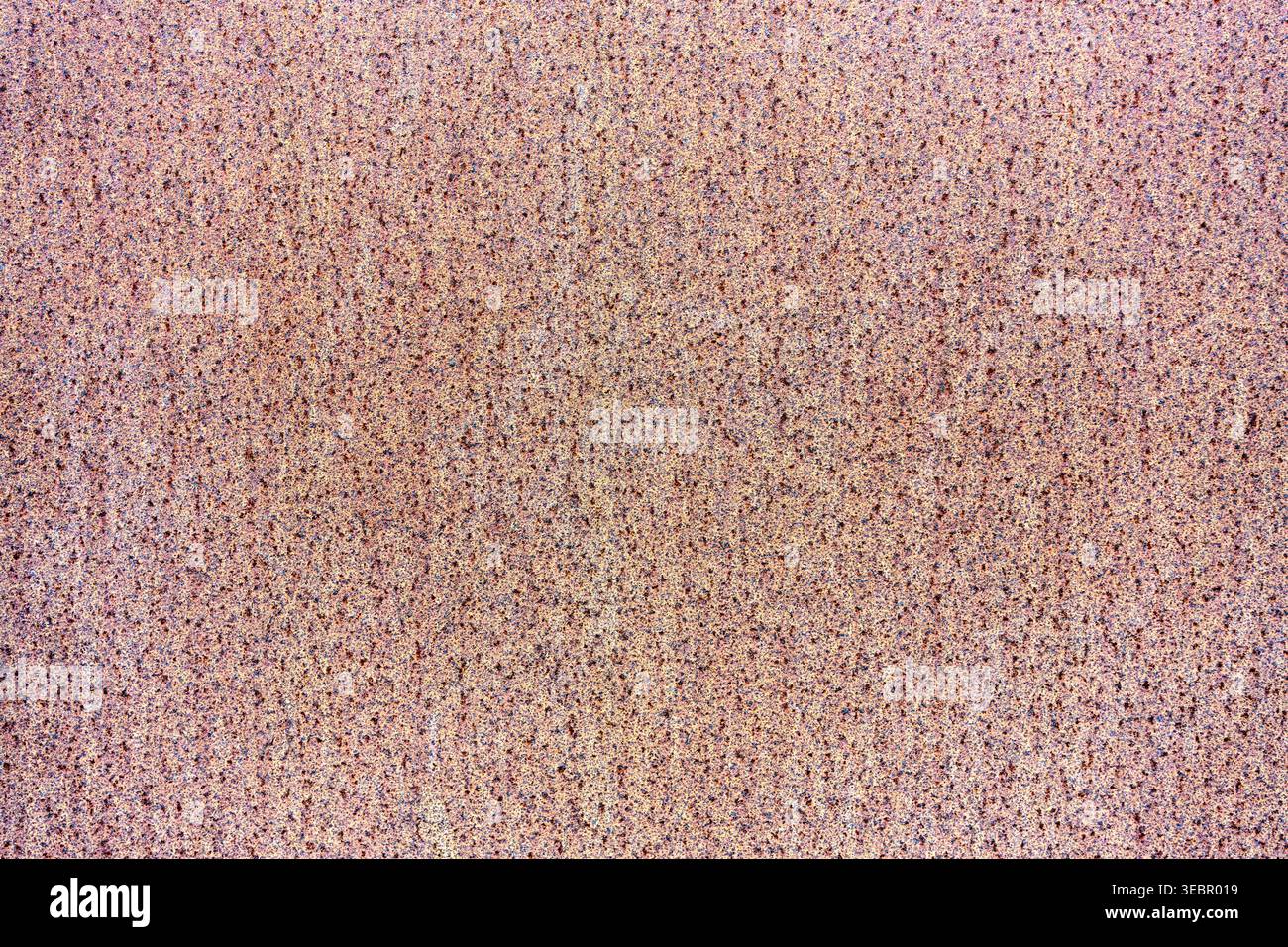 Close-up of a pink and beige speckled texture background with a fine grainy pattern. Neutral abstract surface for design and creative projects. Stock Photo