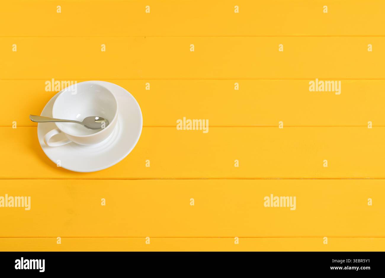 Empty White Cup with Spoon on Yellow Wooden Background Stock Photo
