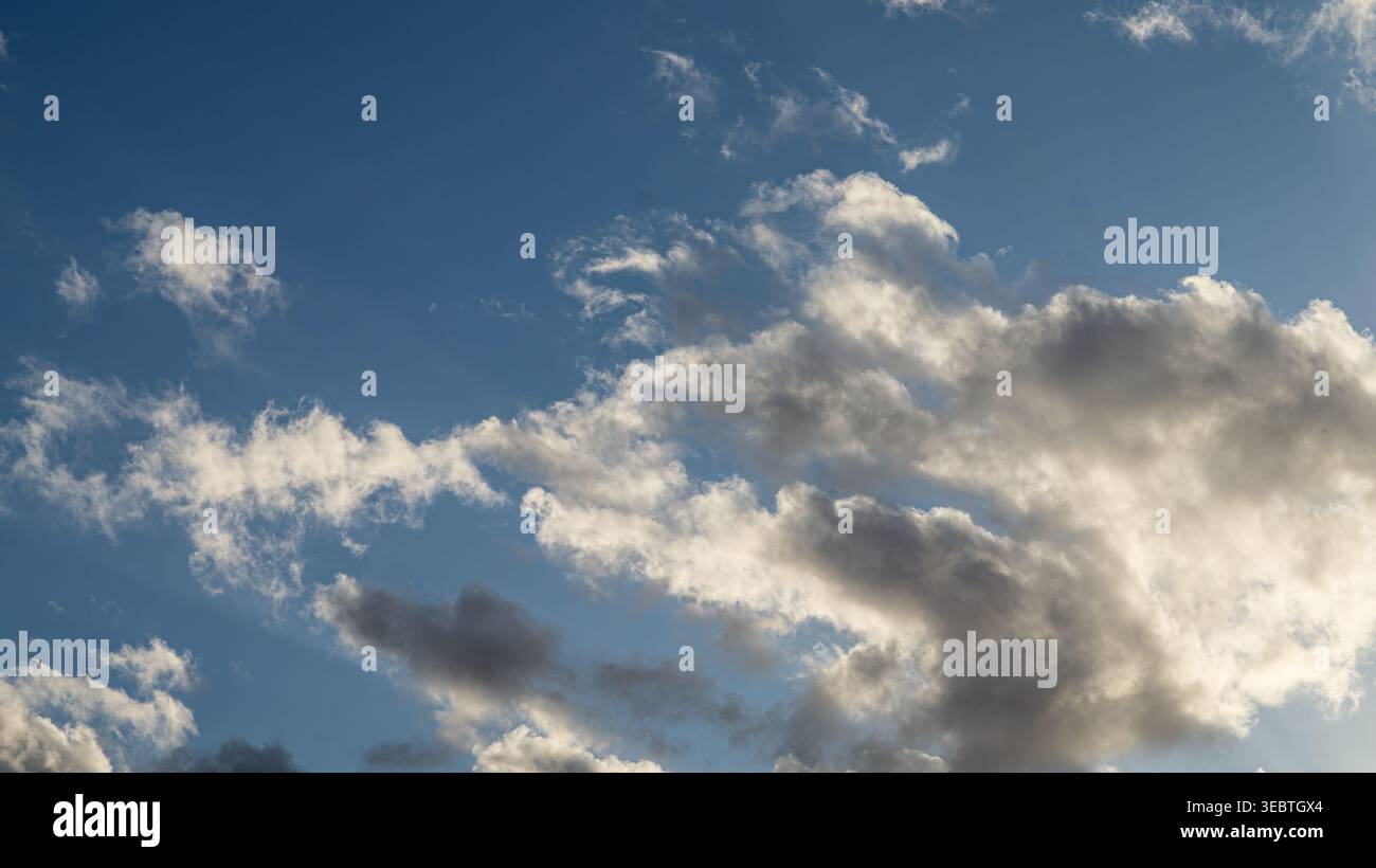 Dramatic cloudscape with cumulus and stratocumulus clouds against blue sky Stock Photo