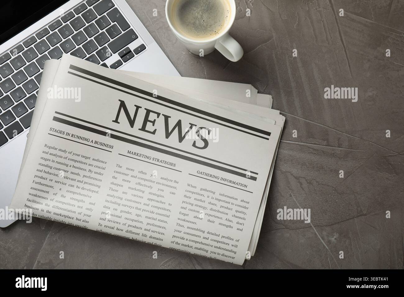 Newspaper, laptop and coffee on grey table, flat lay Stock Photo